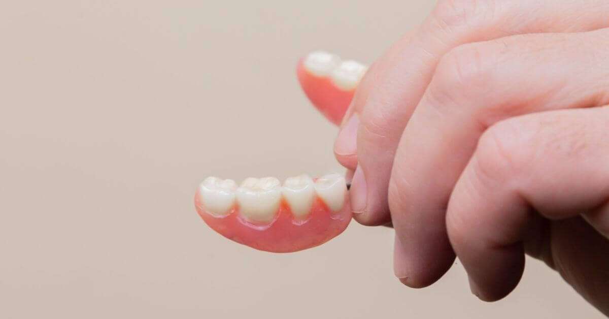 person holding a set of dentures