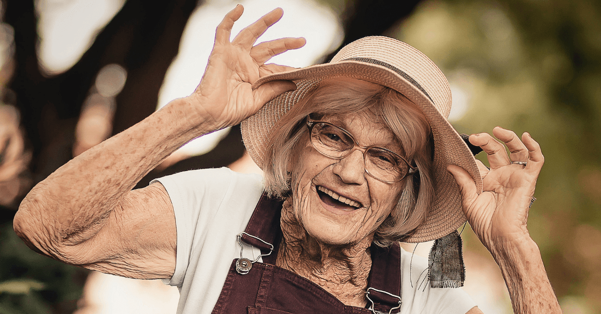 Old woman smiling and wearing a straw hat