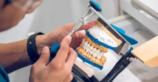 denture clinician hand sculpting a set of dentures